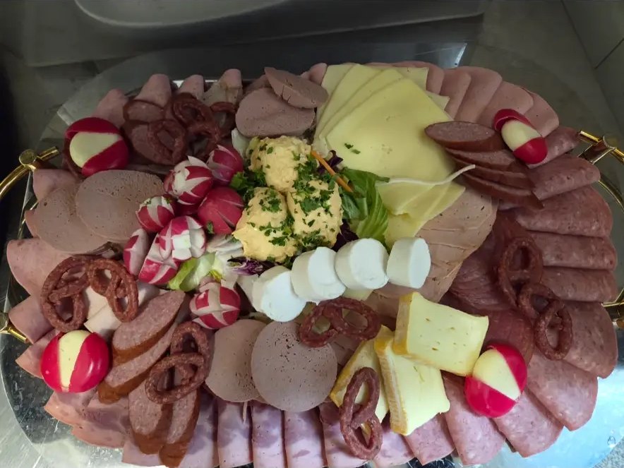 Brotzeitplatte mit Wurst, Käse, Radieschen und Kräuterbutter