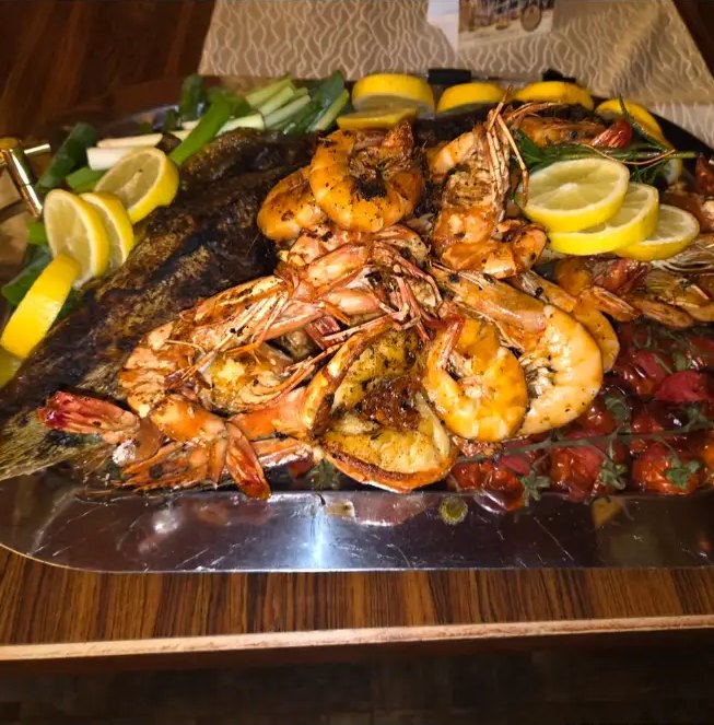 Fischplatte mit Garnelen, Zitronen und Frühlingszwiebeln